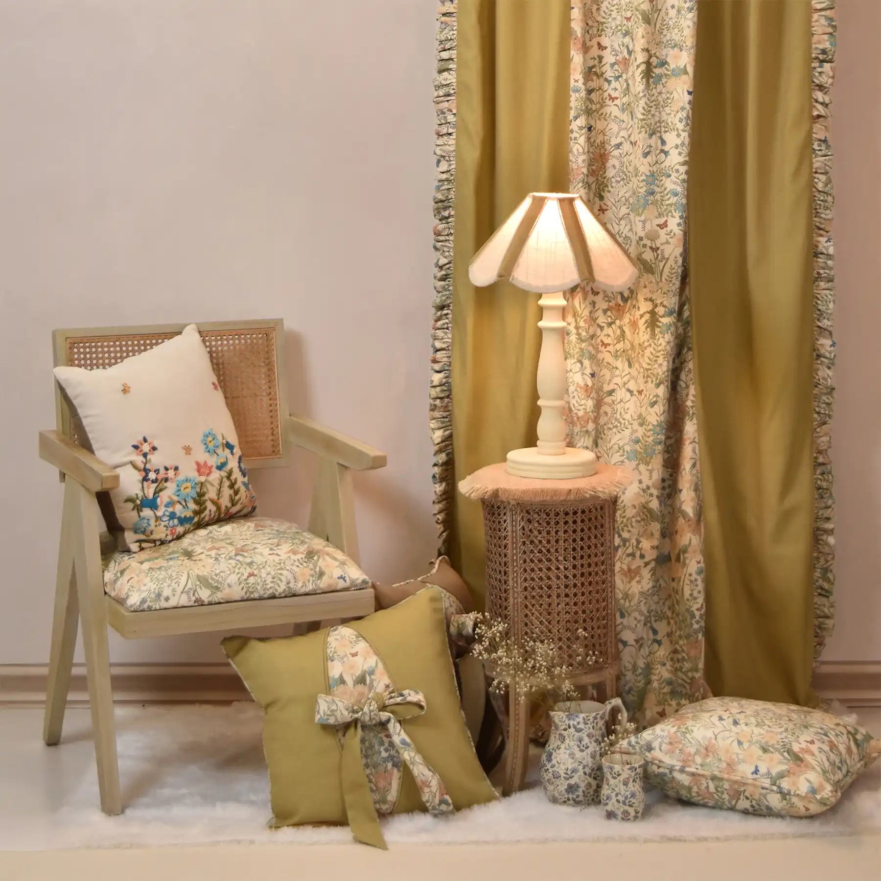 Decorative room setting with a chair, lamp, and floral cushions.